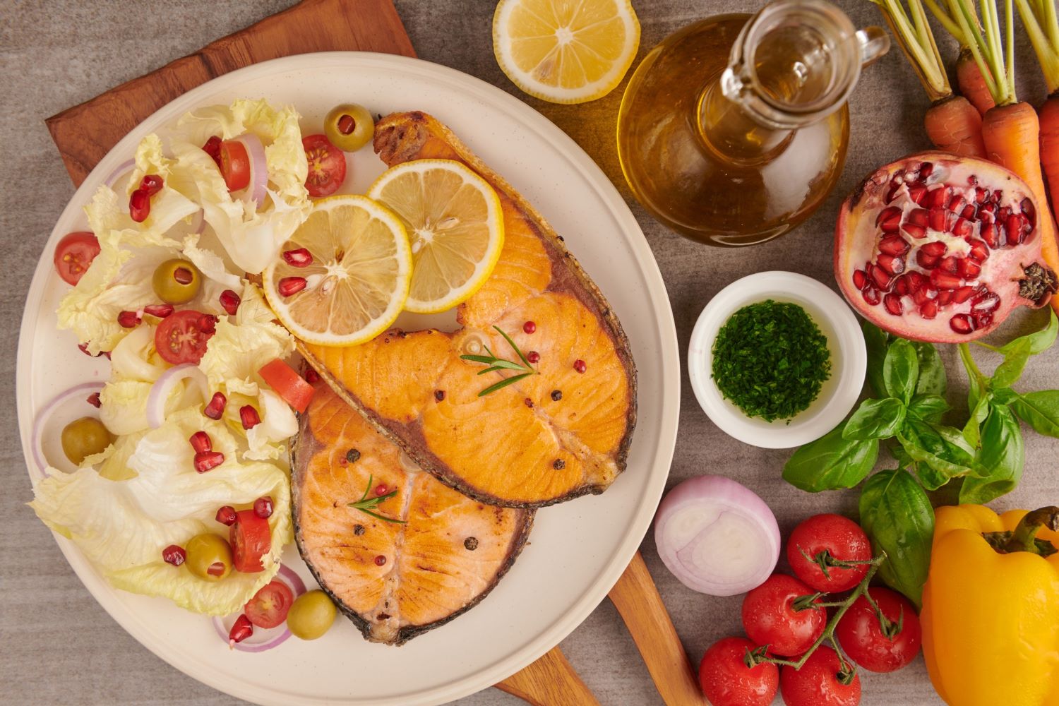 A Mediterranean style plate with salmon, olive oil, roasted vegetables, walnuts and wholegrains.